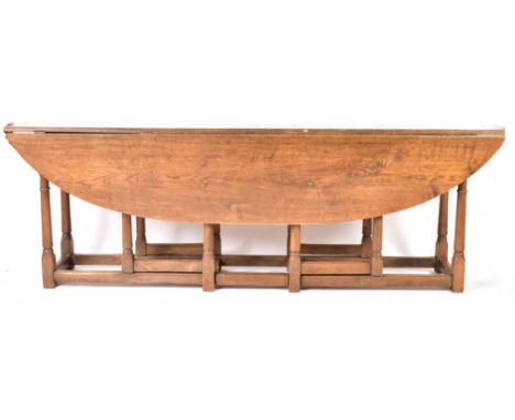 An Irish manner large peg jointed solid oak wake dining table. The large table raised on block and turned legs with gate leg 