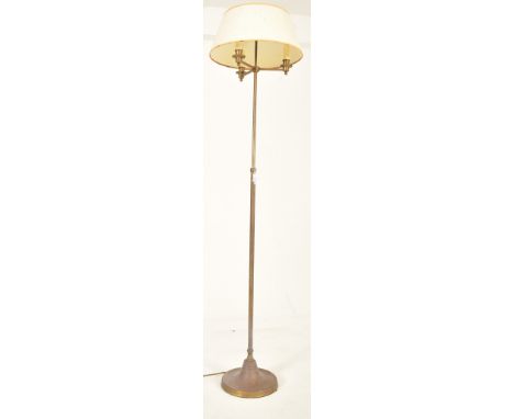 A French inspired brass adjustable floor standard lamp. The lamp having a cream shade over three geometric arms with brass ca