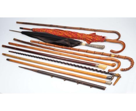 A collection of canes, walking sticks and umbrellas to include a Japanese bamboo cane, a Chinese silver handled umbrella, a h