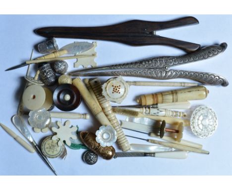 A collection of 19th Century sewing tools including ivory, mother of pearl, thimbles, glove-stretchers, etc