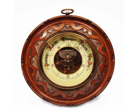 An Edwardian carved walnut cased aneroid barometer 23cm