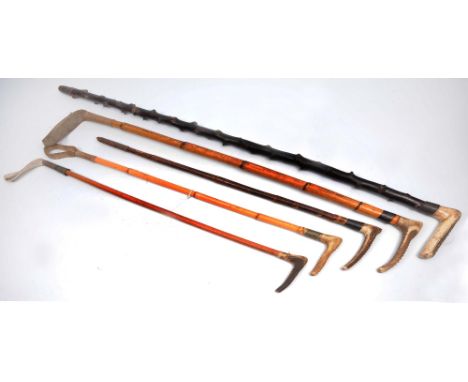 Four riding crops each with a carved bone handle and wooden shaft, largest 76cm, together with a walking stick of similar sty