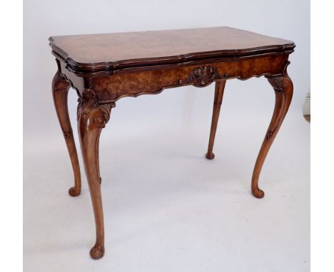 A 20th century walnut fold top card table with scroll craved apron and shell and scroll carved cabriole supports, 90cm square