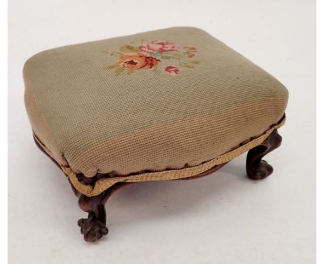 A Victorian tapestry top foot stool on scroll feet 