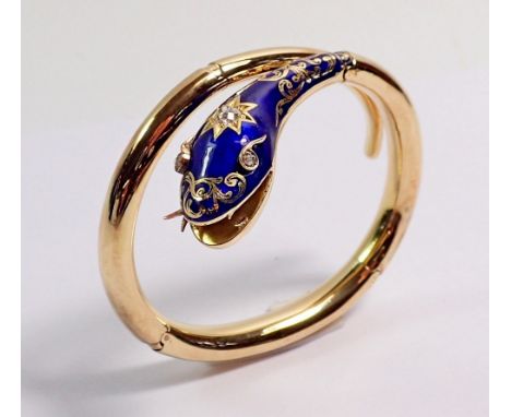 An antique gold snake form bangle with blue enamel and gilt painted head inset diamonds, the open mouth with movable tongue, 
