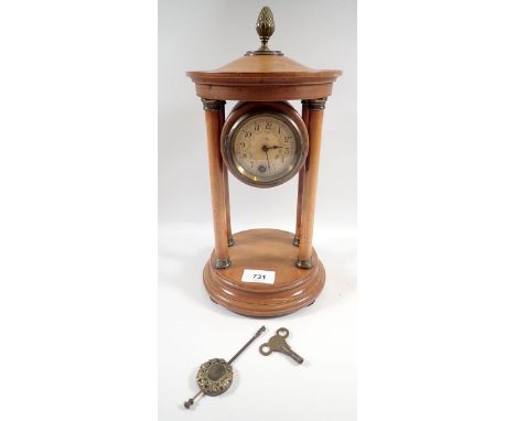 A 19th century circular four pillar wooden mantel clock, 32cm tall 