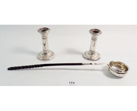 A pair of silver candlesticks, 11cm tall, Birmingham 1910 by Mappin &amp; Webb and a horn  handled white metal punch ladle 