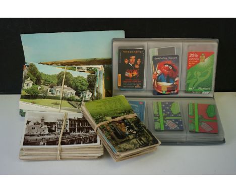 A collection of vintage postcards together with a collection of phonecards contained within a folder. 