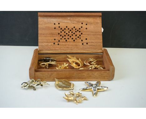 A collection of vintage costume jewellery brooches contained within a decorative wooden box. 