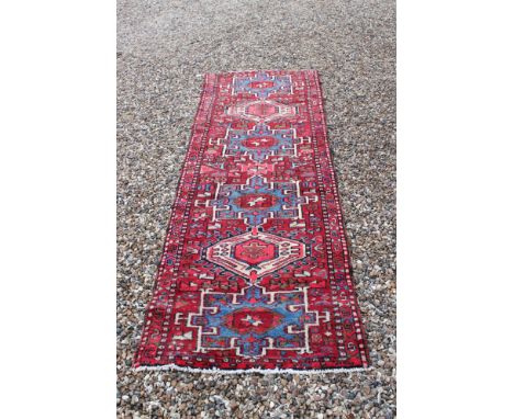 Red and blue ground Persian Heriz Runner of northern Iran, 269cms x 94cms 