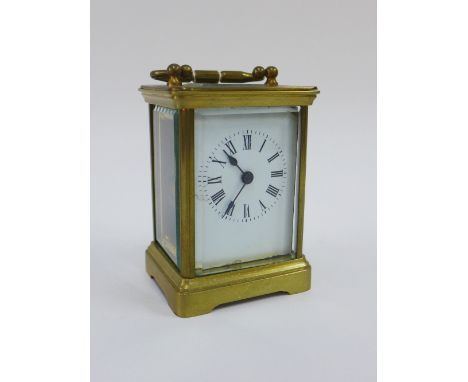 A brass and glass panelled carriage clock of small proportions, complete with key, 13cm high including handle 
