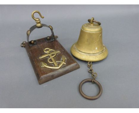 A brass military interest bell on wall bracket