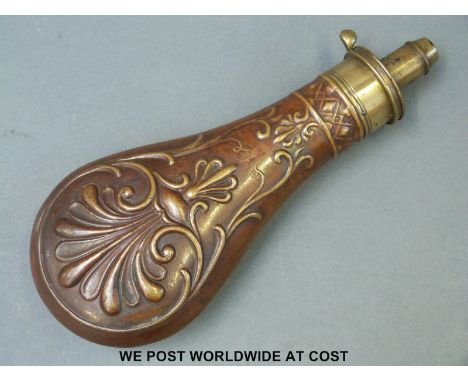 Copper powder flask with embossed scrolling decoration and brass mount.  