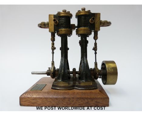 A twin cylinder marine steam engine mounted on a wooden base with plaque for Stevens Model Dockyard, London. This model was p