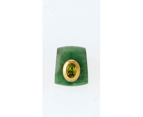 Kissenförmig geschliffene Jade mit integriertem Kettenkanal.  Die Front ist besetzt mit einem hochoval facettierten Peridot i