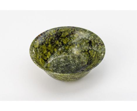 Jade, grün marmoriert. Auf Standring, dünnwandige, tief  gemuldete Schale mit ausgestellter Mündung. Wohl China, 19./20.  Jh.