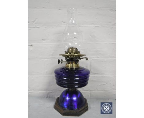 A 20th century oil lamp with glass chimney and blue glass reservoir 