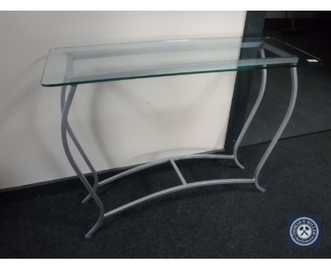 A glass-topped metal console table