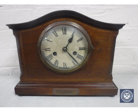 An inlaid mahogany mantel clock with silvered dial