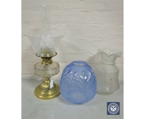 A Victorian brass and glass oil lamp with chimney and shade together with two further glass shades