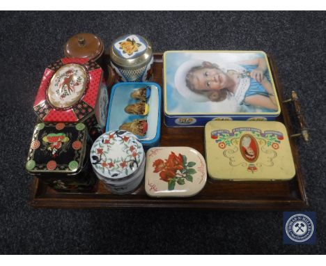 An oak twin-handled serving tray, eight vintage tins and a tea caddy 