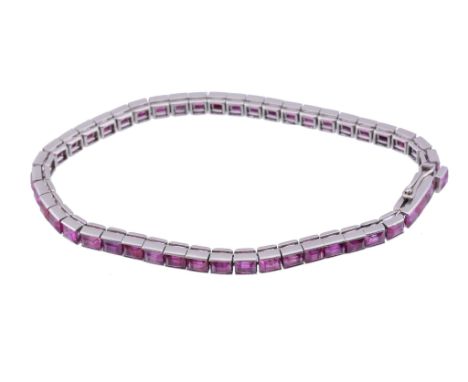  A ruby bracelet,   the channel set step cut rubies in articulated settings, with French poincons to the clasp, 17.8cm long 