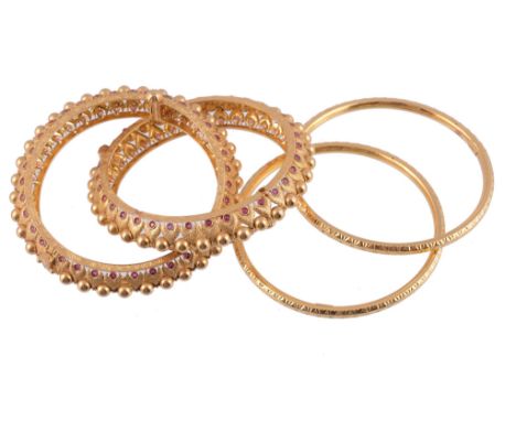  Four gold coloured bangles,   comprising two hinged bangles with red enamel accents, and a pair of hollow bangles, 73g gross