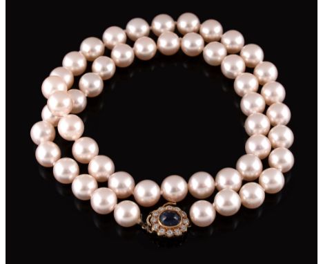  A cultured pearl necklace,   the fifty uniform cultured pearls to an 18 carat gold diamond and cabochon sapphire clasp, with