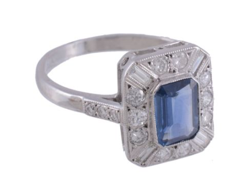  A sapphire and diamond ring,   the central rectangular shaped sapphire collet set within a surround of baguette cut and bril