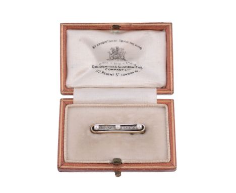  A pink sapphire and half pearl brooch,   the central oval shaped pink sapphire claw set within a pierced scroll surround to 