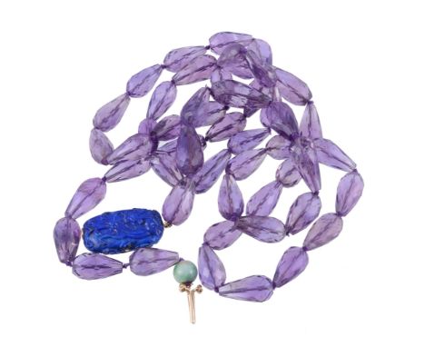  An amethyst necklace,   composed of facetted amethyst beads on a knotted string, to a carved lapis lazuli clasp highlighted 