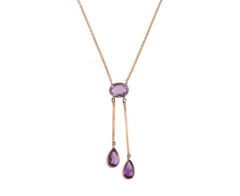  An amethyst pendant,   the oval shaped amethyst in a collet setting suspending two pear shaped amethysts from polished bars,