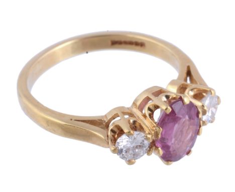  A pink sapphire and diamond ring,   the central oval shaped pink sapphire claw set between two brilliant cut diamonds, stamp