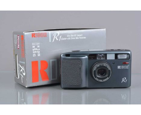 A Ricoh R1 Compact Camera, powers up, shutter working, flash working, self-timer working, body G-VG, elements G-VG, with wris