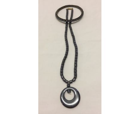 Beaded necklace with circle pendant together with a bangle. 