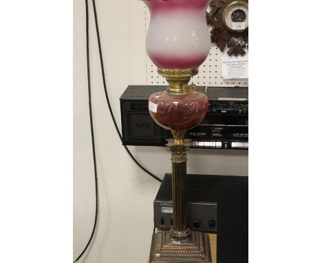 A TWIN DUPLEX BURNER VINTAGE OIL LAMP WITH CRANBERRY STYLE RESERVOIR AND DECORATIVE SHADE