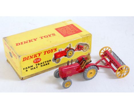 A Dinky Toys box No. 310 farm tractor and hayrake, comprising Massey Harris tractor finished in red and yellow with matching 