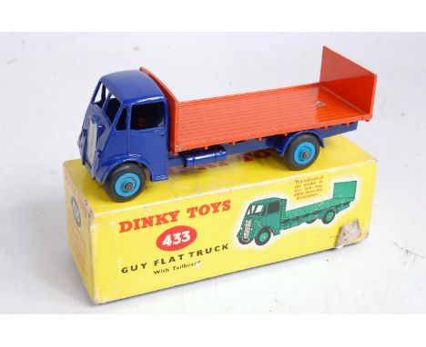 A Dinky Toys No. 433 Guy flat truck with tailboard, comprising dark blue body and orange back with light blue hubs, in the or