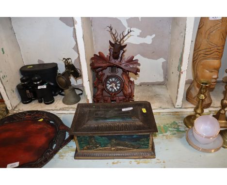 A Black Forest type cuckoo clock and a vintage advertising tin