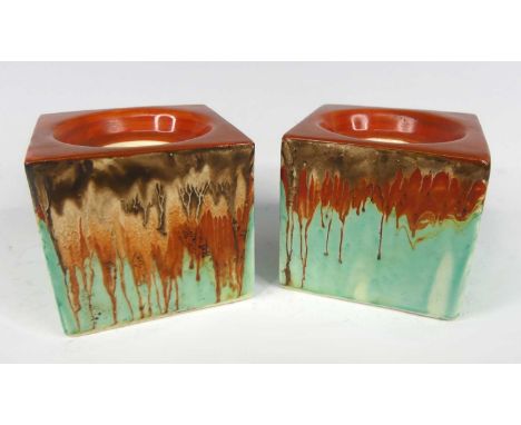 A pair of 1930s Clarice Cliff cube shaped squat pottery candlesticks in the Delecia pattern, black printed backstamp and rais