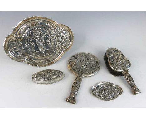 An Art Nouveau silver five-piece dressing table set, having all-over embossed floral sinuous decoration with opposing standin