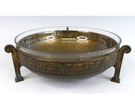 An Austrian Secessionist hammered brass and glass inset circular fruit bowl, raised on scroll tapering supports, dia.26cm Gla