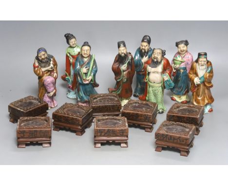   A set of eight 20th century Chinese porcelain figures of immortals, 15cm, each on carved wood stand