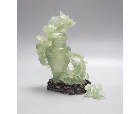   A Chinese green bowenite jade group modelled as a covered urn surrounded by a dragon, H 26cm with carved stand