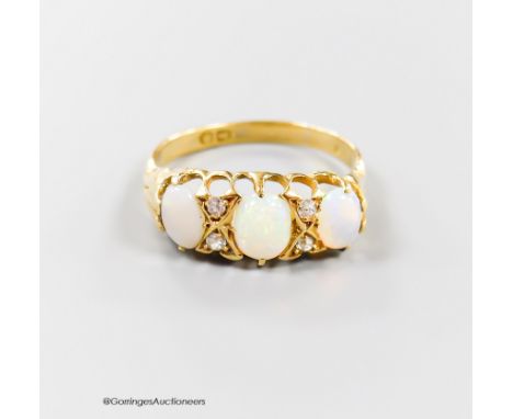   An Edwardian yellow metal, three stone opal and four stone diamond chip set half hoop ring, size Q/R, gross 3.5 grams.