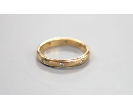   A modern 14k and gypsy set eight stone diamond eternity ring, size R/S, gross 4.3 grams.