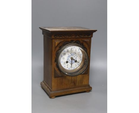   An Edwardian walnut mantel clock, with decorative dial, height 26cm