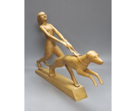   An Art Deco style light elm carving of a woman and dog on lead-weighted plinth, height 40cm