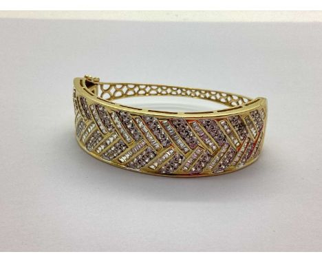 A Modern Wide Front Hinged Bangle, channel and millegrain set throughout to the front (one stone missing), tapering slim pier