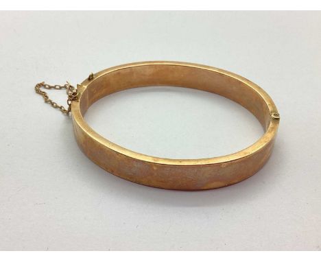 A 9ct Rose Gold Hinged Bangle, hollow, of plain design, hinged to snap clasp (safety chain broken / dents) (10grams).